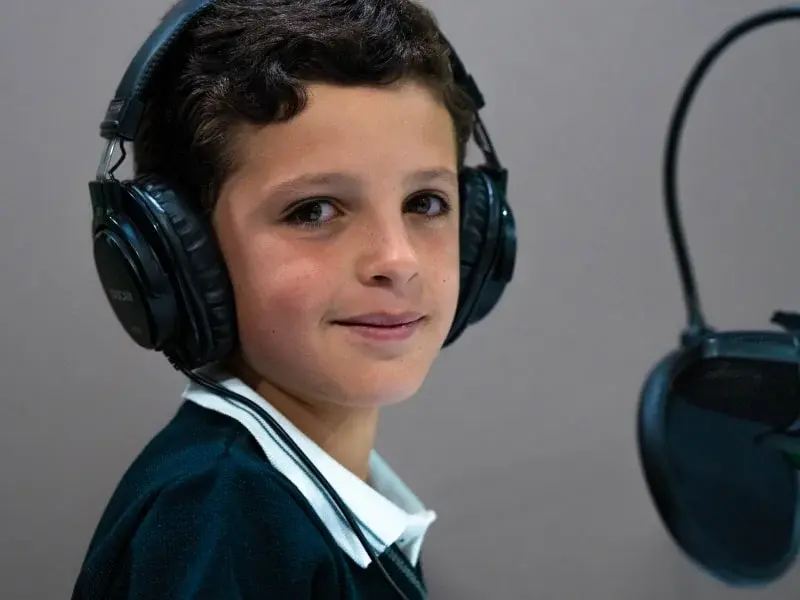 Estudiante con auriculares en sesión de aprendizaje digital en el aula